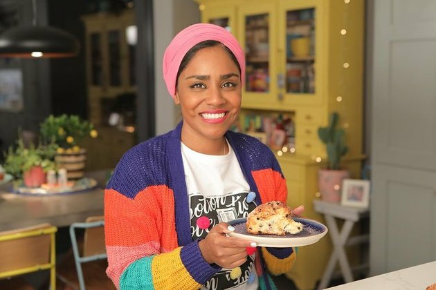 nadiya hussain na cozinha segurando um prato com assados