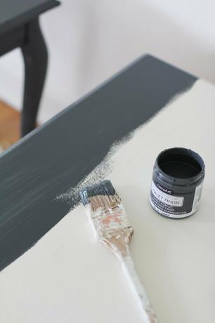 Ant baltų baldų dažykite teptuką ir mažą skardinę šiferio spalvos dažus.
