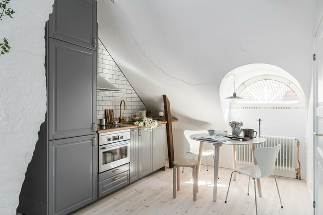 cozinha do sótão branco com pequena mesa e cadeiras