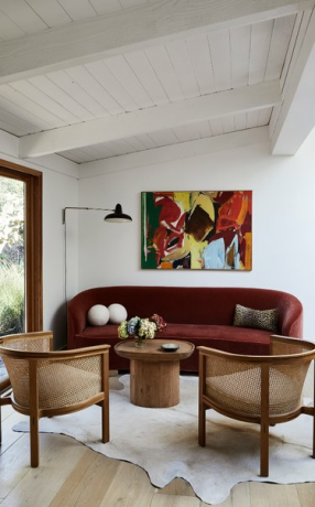 Minimalistisk stue med rødbrun sofa og hvide vægge.