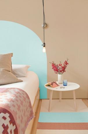 PPG Pinta a cor de tinta aqua enevoada na parede cercada por cama e mesa de cabeceira com flores