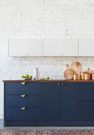 cozinha de dois tons com armários superiores brancos e armários de beadboard azul marinho