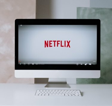 logo netflix sul desktop imac su scrivania bianca