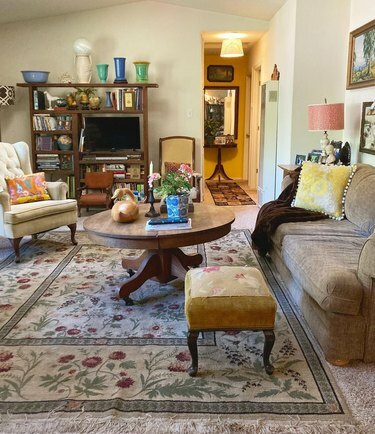 dzīvojamā istaba ar botāniski apdrukātu paklāju, kas uzklāts virs paklāja