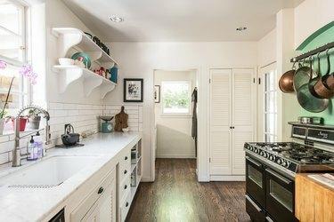 virtuvės virtuvė su atviromis viršutinėmis lentynomis ir baltomis spintelėmis
