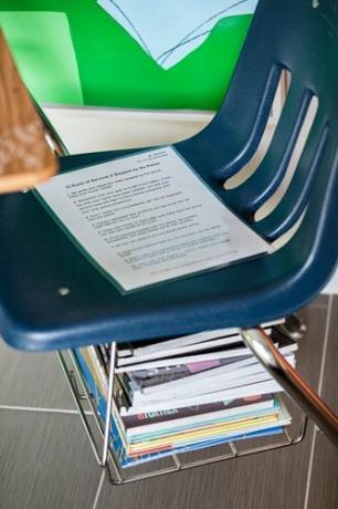 Scrittorio blu dell'aula con la pila di libri sotto