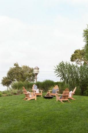 Idee per arredare un patio ricoperto di erba con sedie adirondack