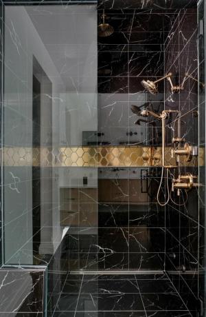 chuveiro elegante em azulejo preto com acabamento em mármore e acessórios com acabamento em ouro