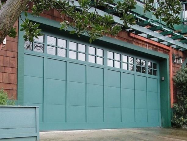 porta da garagem azul-verde em casa de telhas de madeira
