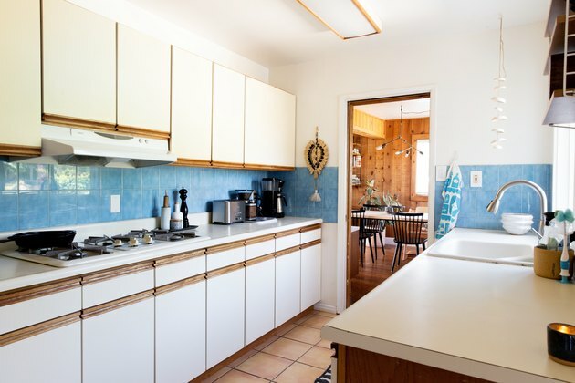 Cozinha em branco, madeira e backsplash azul claro.