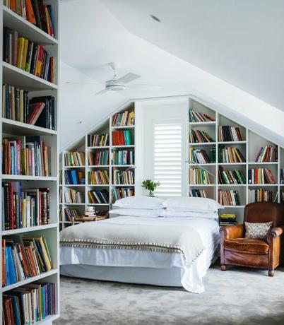 pequena biblioteca do sótão e quarto com paredes de estantes