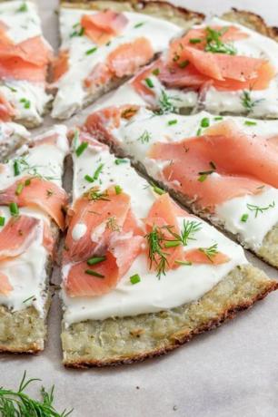 Lähikuva Smoked Salmon Latke Pizzasta valkoisella marmoritasolla.