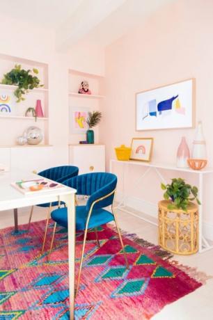 escritório doméstico em rosa pastel com tapete rosa brilhante e cadeiras de escritório de veludo azul