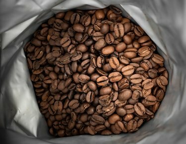 grãos de café marrons em saco de papel alumínio