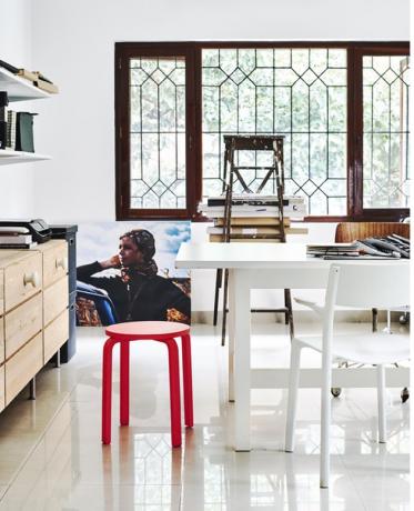 Escritório doméstico escandinavo com mesa branca e banco vermelho