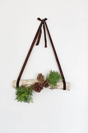 decoração de toras penduradas com pinhas e grama