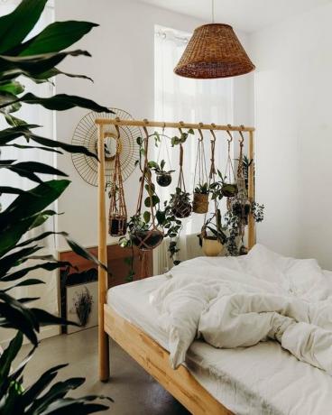 augalų tematikos miegamasis su plantacijomis, kabamomis iš IKEA lovos rėmo