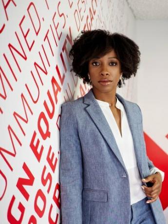 fotografia de Kia Weatherspoon contra uma parede branca e vermelha com texto