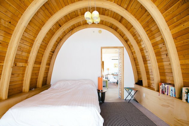 Camera da letto con pareti curve in legno