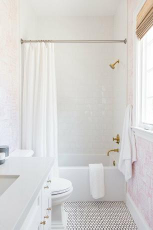 chuveiros tradicionais com azulejos brancos e papel de parede rosa