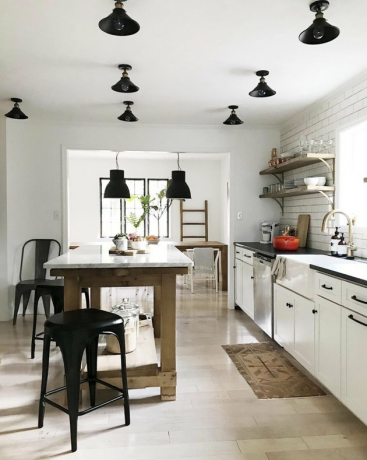 Witte keuken House Seven Design met zwarte plafondverlichting en eiland met marmeren blad