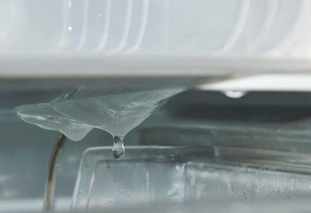 Eau dégoulinant de glace dans le réfrigérateur pendant le dégivrage et le nettoyage