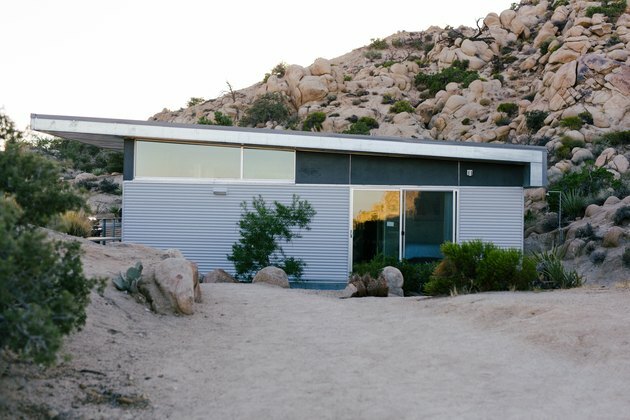 uma casa pré-fabricada com ideias externas de vidro e metal corrugado
