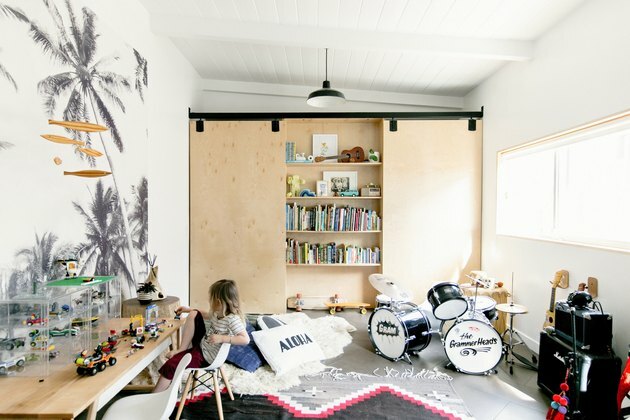 Speelkamer met muziekinstrumenten en speelgoed en verborgen boekenplank