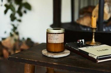 P.F. Candle Co. logorska vatra svijeća ispred hrpe drva