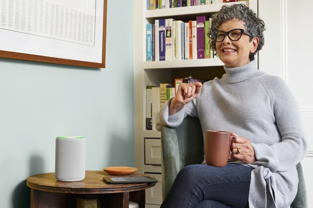 vrouw zitten met mok in de buurt van Amazon Echo