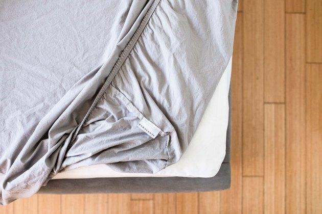 lençol cinza justo no meio da cama
