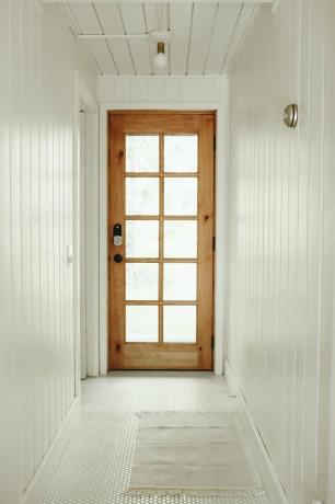 Cabine minimalista com estrutura em A de inspiração escandinava na floresta Lilla Norr com iluminação contemporânea no vestíbulo