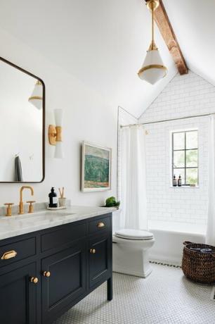 moderni valkoinen ja messinki riippuvalaisin perinteisessä kylpyhuoneessa