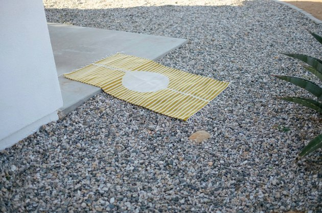 Tapete ecológico listrado de amarelo e branco estendido no solo no deserto