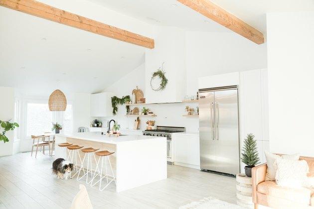 Cozinha boho branca com grande ilha branca e bancos de balcão e ilha de cozinha contemporânea