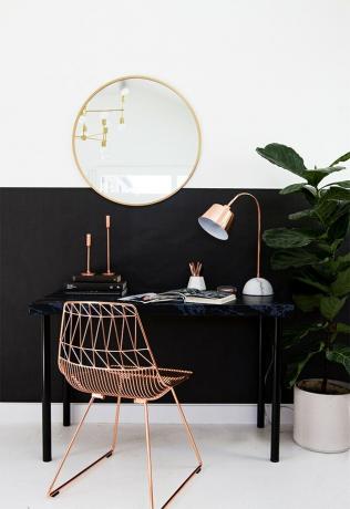 مكتب منزلي صغير مع حجب اللون الأسود وكرسي إطار من الذهب الوردي