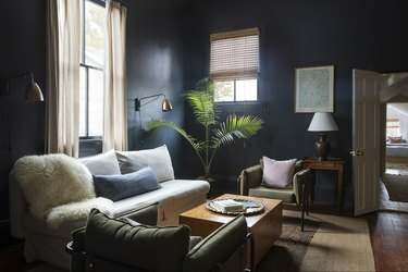 mørkeblå stue med oliven lænestole og vintage møbler