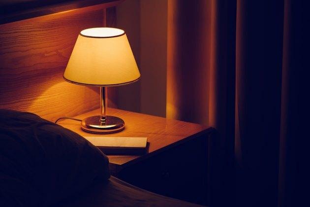 Elektriskā lampa un grāmata uz gultas