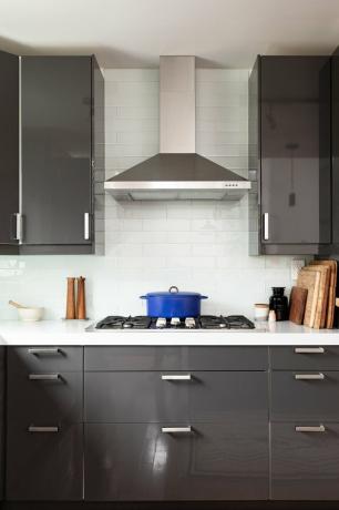серые кухонные шкафы, плита и вытяжка из нержавеющей стали