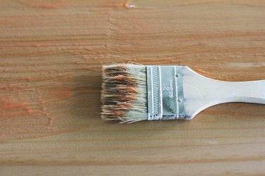 Детайл от използвана бяла четка за рисуване върху дървена повърхност