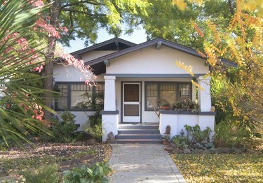 Exterior frontal de um bangalô branco com detalhes em azul