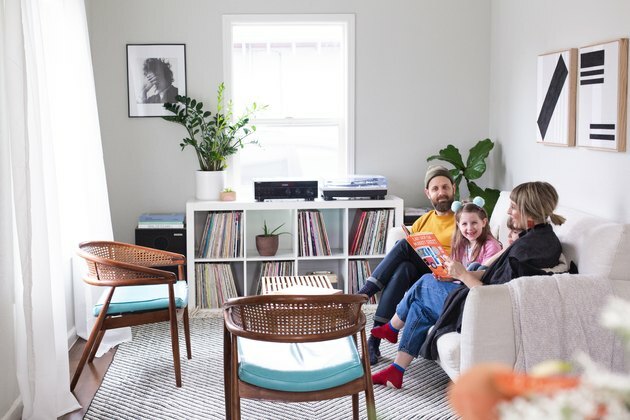 غرفة عائلية مع أسرة جالسة على الأريكة بين الديكور الحديث
