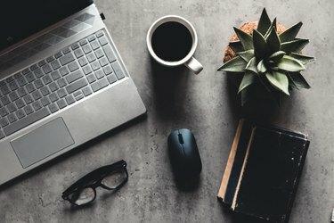 laptop e libro, caffè su sfondo grigio, vista dall'alto della scrivania dell'ufficio su texture