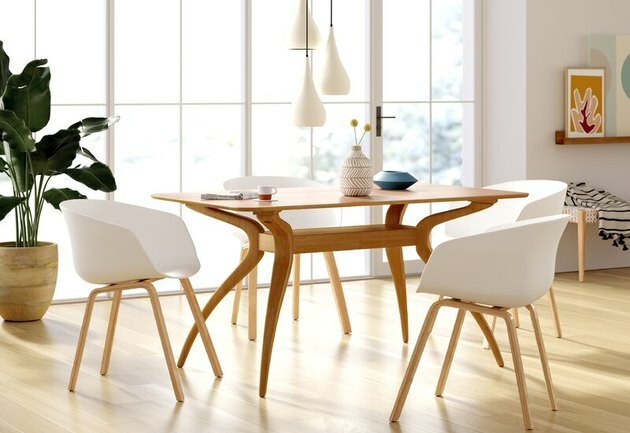 الحد الأدنى فكرة غرفة الطعام مع طاولة خشب منتصف القرن وكراسي بيضاء مع إضاءة معلقة أعلاه