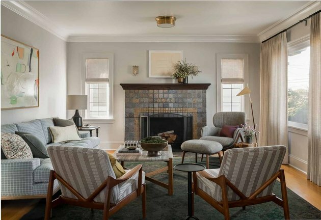 ألوان غرفة العائلة الرمادية الناعمة مع سقف أبيض وكراسي منقوشة