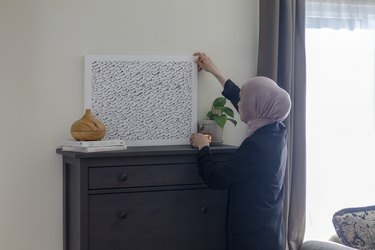 سمر سعد تضع عملاً فنيًا على طاولة تزيينها الخشبية