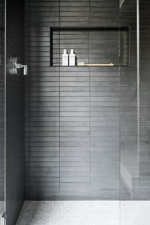 chuveiro em azulejo preto contemporâneo com recanto para armazenamento