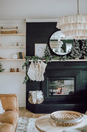 Lareira preta com meias de macramê, decoração boêmia e lustre com borlas