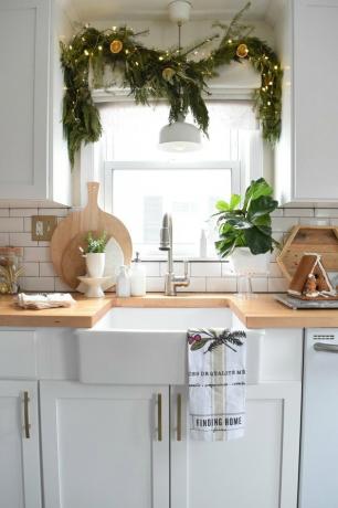 cozinha branca com decorações de janela de Natal