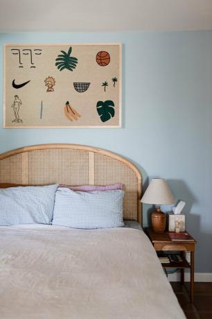 لوحة ألوان منزل صحراوي باللون الأزرق والبيج في غرفة النوم مع هيكل سرير من الروطان وتعليق حائط